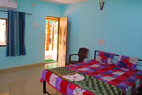 a bedroom with a bed and a chair in it at Athaang Beach Resort in Malvan