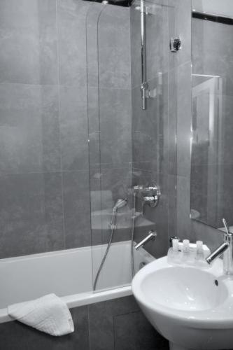 a bathroom with a shower and a sink and a tub at Hôtel Albe Saint Michel in Paris