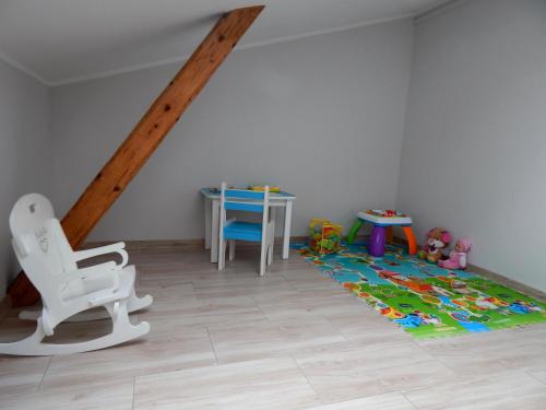 a room with a chair and a table and a rug at Apartamenty "Kotlina" in Bystrzyca Kłodzka