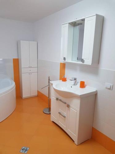 a bathroom with a white sink and a toilet at Pensiunea Casa Rumpel in Gura Humorului
