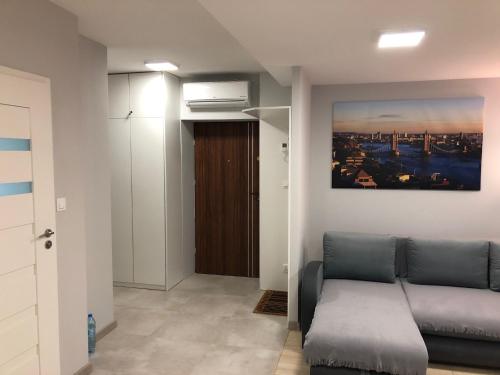 een woonkamer met een bank en een schilderij aan de muur bij Klimatyzowany Apartament Londyn in Kielce