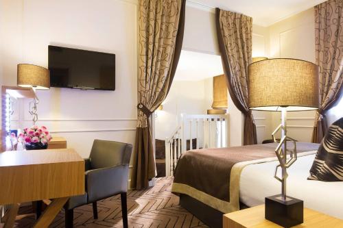 Giường trong phòng chung tại Hôtel Galileo Champs Elysées