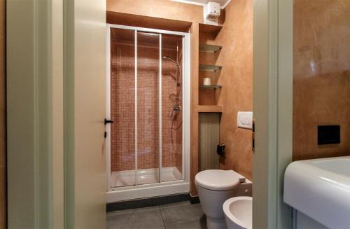 a bathroom with a toilet and a glass shower at Appartamenti Volta in Como
