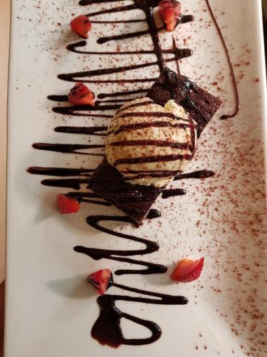 a white plate with a piece of chocolate cake and strawberries at The Inn On The Green in Ockley