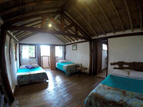 a bedroom with two beds in a room with wooden floors at Ecorefugio Las Mirlas in Salento