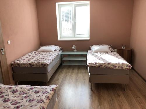 Zimmer mit 2 Betten und einem Tisch in der Unterkunft Apartment KOPA L in Vyhne