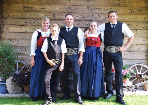 a family posing for a picture in front of a cabin at Schorpenhof in Fügenberg