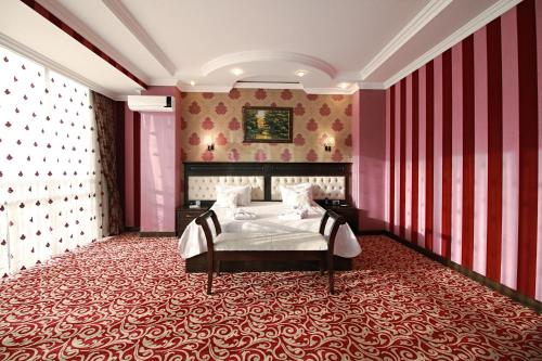 a bedroom with a bed and a red wall at New Baku Hotel in Baku