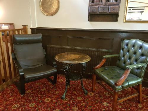 a room with two chairs and a table at The Inn On The Green in Ockley
