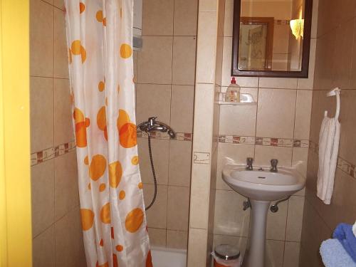 a bathroom with a shower curtain and a sink at Gast House in Faro