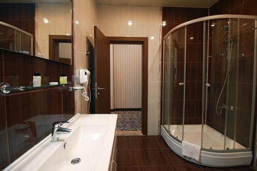 a bathroom with a tub and a sink and a shower at New Baku Hotel in Baku
