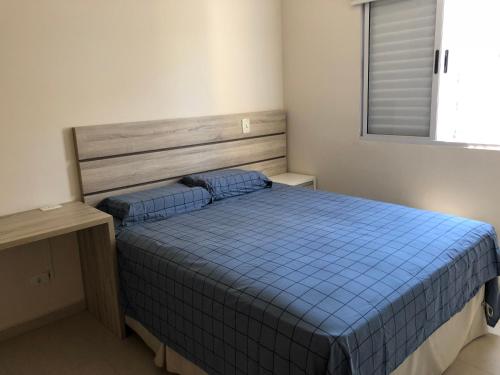 a bedroom with a blue bed and a window at MARAÚ Premium - espaço, piscina e ar no Itagua in Ubatuba