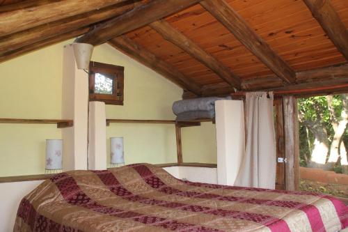a bedroom with a bed and a wooden ceiling at La Casa de Wanda in Villa de Las Rosas
