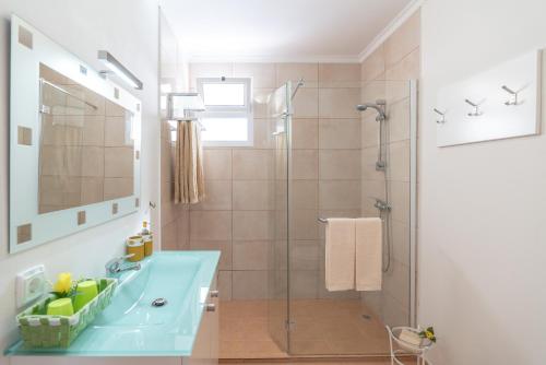 a bathroom with a shower and a blue sink at Casa Sol e Vista in Arco da Calheta