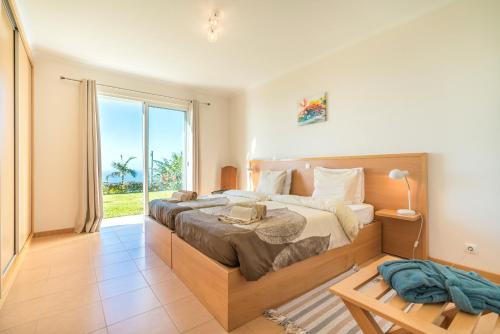 a bedroom with a large bed and a large window at Casa Sol e Vista in Arco da Calheta