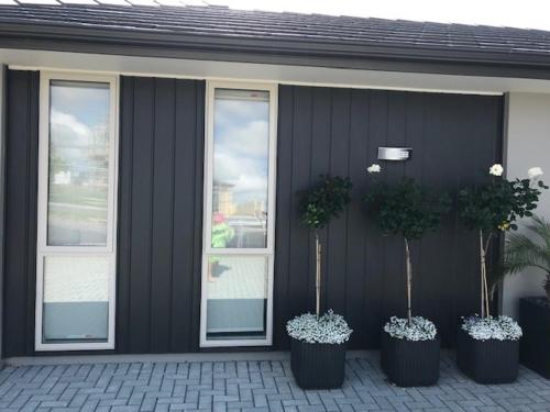three potted plants on the side of a building at Modern Self Contained Apartment in Riverhead in Riverhead