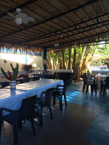 a restaurant with tables and chairs and a piano at Sana El Jardin Secreto in Santiago de los Caballeros
