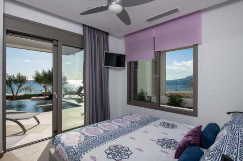ein Schlafzimmer mit einem Bett und einem Balkon in der Unterkunft Moonlight Seafront Apartments in Koutsourás