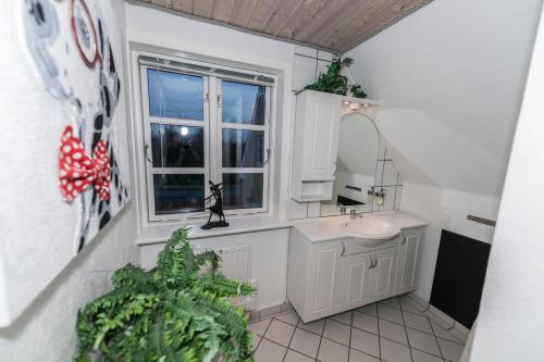 a bathroom with a sink and a window at Toftegården Guesthouse - Rooms in Skagen