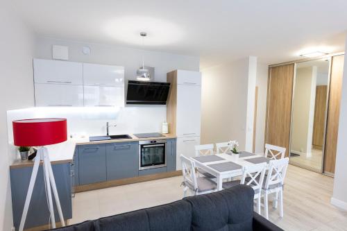 uma cozinha e sala de estar com mesa e cadeiras em Apartament 4k Nautica Szczecin em Szczecin