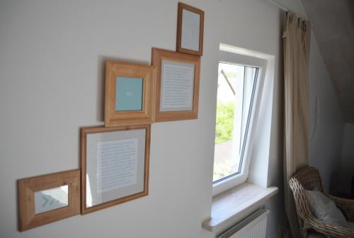 a wall with three pictures and a window at SAKÀ Vacation House in Druskininkai