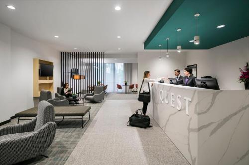 a lobby with people sitting at a reception counter at Quest Notting Hill in Clayton North