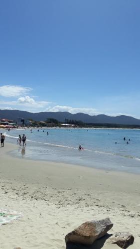 a group of people playing in the water on a beach at Pousada Mar Verde in Florianópolis