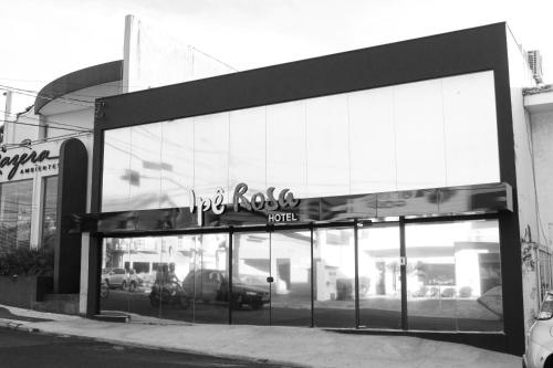 un frente de tienda con un cartel en la parte delantera en Ipê Rosa Hotel, en Bauru