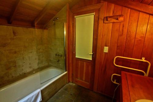 y baño con bañera y ducha. en Casa La Veleta en San Martín de los Andes