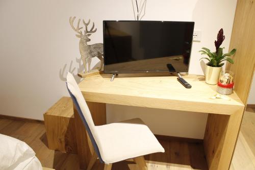 un escritorio de madera con TV encima en Gasthof Zum Hirschen Margreid, en Magrè allʼ Adige