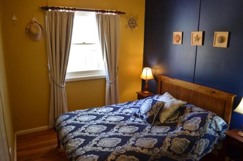 a bedroom with a bed and a window at Casa Husky in Huskisson