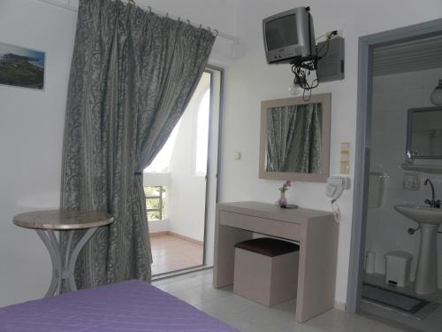 a room with a bathroom with a sink and a window at Megim Hotel in Palaiochóra