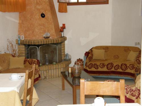 a living room with a couch and a fireplace at Megim Hotel in Palaiochóra