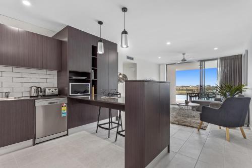 a kitchen with a counter and a dining room at North Shore Oceanside Kawana in Kawana Waters