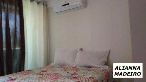 a bedroom with a bed with a comforter and a window at FLAT EM INTERMARES in Cabedelo