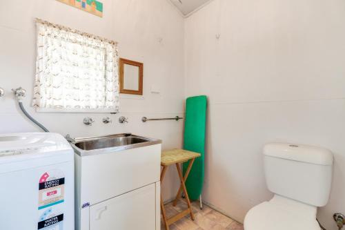 a small bathroom with a sink and a toilet at Beacon Cottage in Lake Tyers