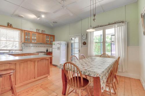 a kitchen with a table and chairs and a refrigerator at Beacon Cottage - Cosy Family Retreat in Lake Tyers