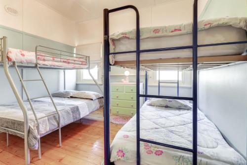 a bedroom with two bunk beds in a room at Beacon Cottage in Lake Tyers