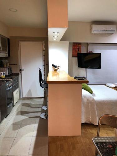 Habitación con cama y cocina con encimera. en Apartamento Monoambiente amplio 2 baños balcón Hospital Italiano Almagro en Buenos Aires