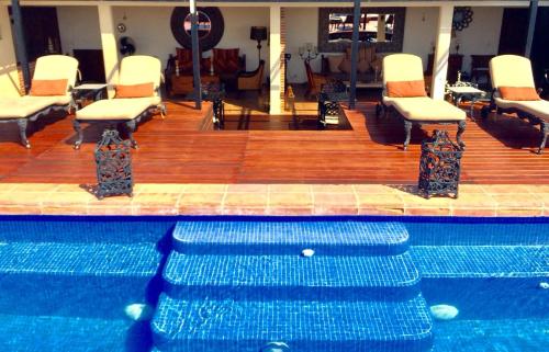 a swimming pool with white chairs and a table and a pool at La Pasion Colonial Hotel Boutique By Bunik in Playa del Carmen