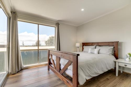 a bedroom with a bed and a large window at Outlook Views in Lake Tyers