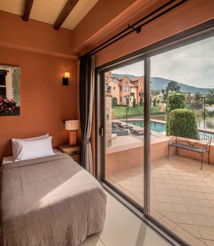 a bedroom with a bed and a sliding glass door at Toscana Hotel La Casetta in Mu Si