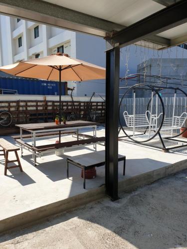 a group of picnic tables and an umbrella at A-Mong B&B (Qingshui) in Qingshui