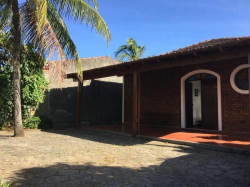 a brick house with a palm tree in front of it at Casa da Dazinha in Guarapari
