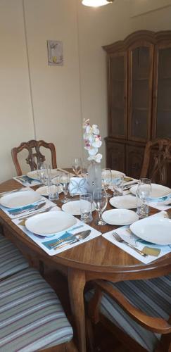una mesa de madera con platos y vasos. en IMPERIAL Apartamento, en La Paz