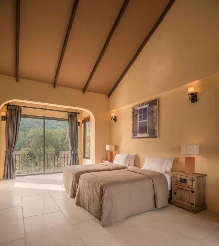 a bedroom with two beds and a large window at Toscana Hotel La Casetta in Mu Si