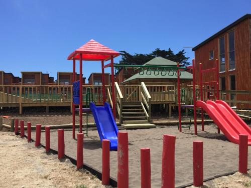 a playground with colorful playground equipment in the sand at Condominio Privado a Pasos del Mar in Pichilemu