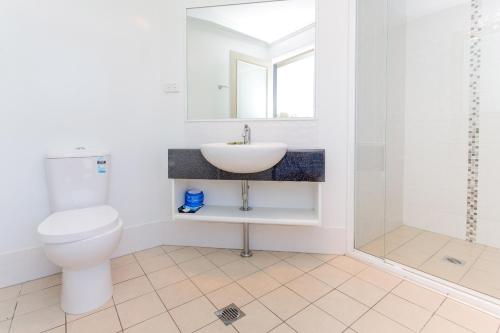 a bathroom with a toilet and a sink and a shower at BIG4 Gold Coast Holiday Park in Gold Coast