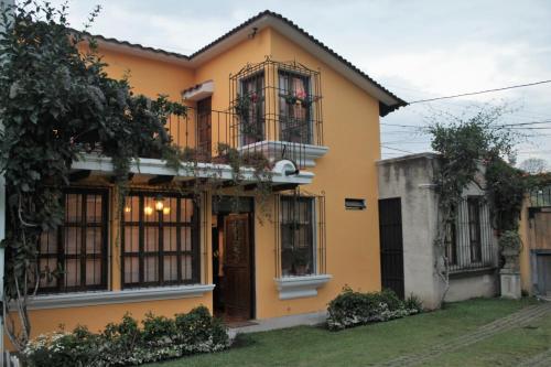 a yellow house with windows and a balcony at Villas Santa Ana-Ricardo in Antigua Guatemala