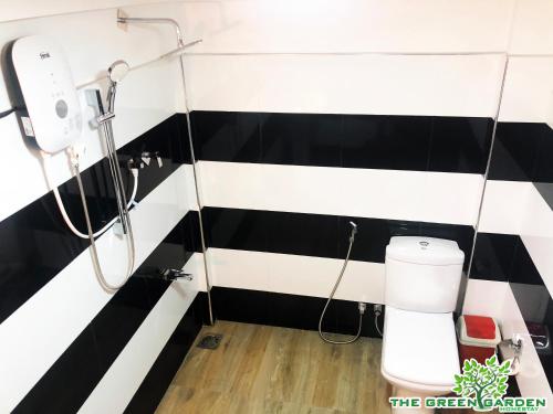 a bathroom with black and white striped walls and a toilet at The Green Garden in Dambulla